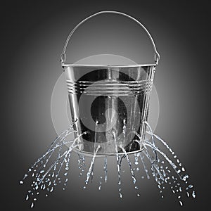 Leaky bucket with water on background