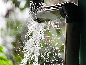 Leaky rain gutter pipe in the midst of a downpour