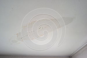 Leaky roof dampness in bedroom ceiling walls. Water droplets forming and dripping from damp ceiling from rain water flooding.