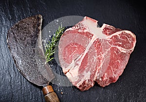 Lean matured raw t-bone steak and vintage cleaver