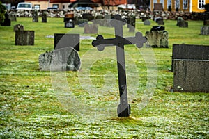 Leaning metal cross on a grave yard..