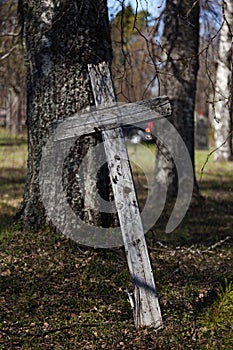 Leaning old wooden cross in abandoned cemetery