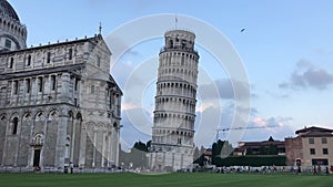 Leaning Tower of Pisa, tourists are walking around. Evenings