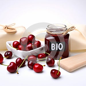 ?lear glass jar filled with cherry jam and berries sits next to wooden sign bearing word Bio.