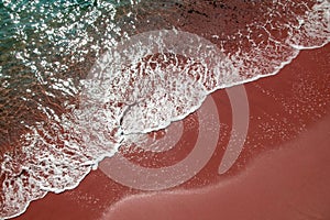 ?lear ocean wave on red sandy beach, colorful sea ??wave texture, unusual water background