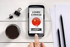 Learn Chinese concept on smart phone screen with office objects