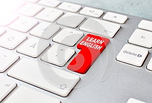 Learn English language online advice. Concept with keyboard and red button. E-learning background