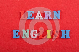 LEARN ENGLISH word on red background composed from colorful abc alphabet block wooden letters, copy space for ad text. Learning