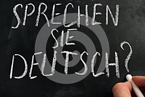 Learn German. Sprechen Sie Deutsch sign on a blackboard photo