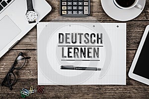 Learn German on notepade at office desk with computer technology