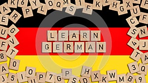 Learn German word written with wooden tiles over German flag