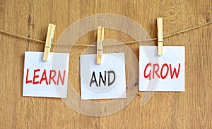 Learn and grow symbol. Concept word Learn And Grow on beautiful white paper on wooden clothespin. Beautiful wooden table wooden