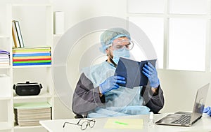 Learn how protect yourself. Man reading book. Medical research. Worker in protective equipment. Doctor studying