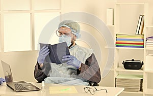 Learn how protect yourself. Man reading book. Medical research. Worker in protective equipment. Doctor studying