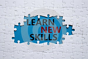Learn new skills symbol. Concept words Learn new skills on white puzzle. Beautiful blue background. Business and Learn new skills
