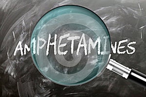 Learn, study and inspect Amphetamines. A magnifying glass enlarging word \'amphetamines\' written on a blackboar photo