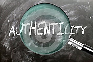 Learn, study and inspect Authenticity. A magnifying glass enlarging word \'authenticity\' written on a blackboar photo