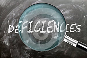 Learn, study and inspect Deficiencies. A magnifying glass enlarging word \'deficiencies\' written on a blackboar photo