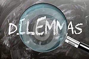 Learn, study and inspect Dilemmas. A magnifying glass enlarging word \'dilemmas\' written on a blackboard photo