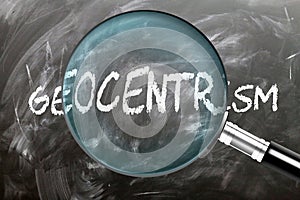 Learn, study and inspect Geocentrism. A magnifying glass enlarging word \'geocentrism\' written on a blackboard photo