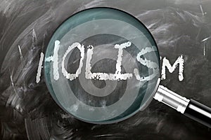 Learn, study and inspect holism - pictured as a magnifying glass enlarging word holism, symbolizes researching, exploring and photo