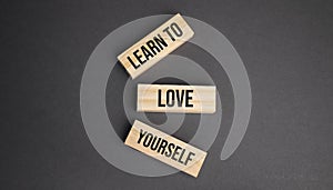 Learn to love yourself word written on wood block. objective text on table, concept