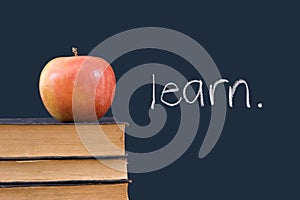 Learn written on blackboard with apple and books