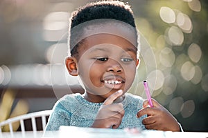 Learning can be fun. a young boy having fun writing outside.