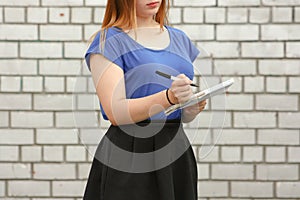 Learning concept. The girl is at the white brick wall. Photo