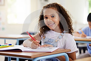 Learning, drawing and portrait of girl in classroom exam, education or studying with book. Preschool smile, development