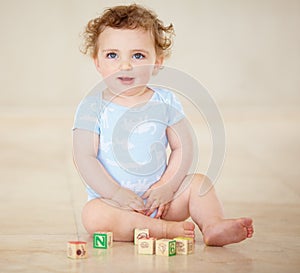 Learning is fun for a curious little boy. Full length shot of a cute baby boy playing with toy blocks.