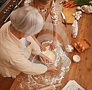 Learning grandmas secret recipes. a young woman learning baking tips from her grandmother.