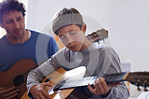 Learning, guitar and child with teacher for music, lesson and development of skill with instrument. Playing, practice