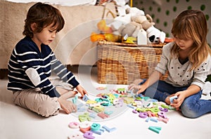 Learning isnt only for school. two adorable siblings playing with colorful toy letters.
