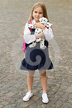 Learning starts with playing. Little child hold toy dog outdoors. Pretend play. Back to school essentials. Early