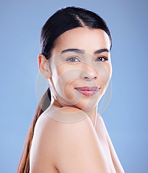 Learning to love myself the way I am. an attractive young woman posing alone against a blue background in the studio.