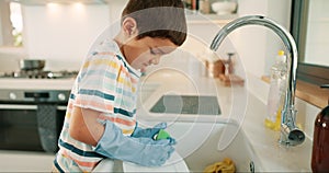 Learning, washing dishes or kid with dirty plate or gloves in kitchen sink at home for hygiene. Messy, child development