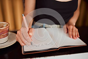 Learning woman writing in notebook, university student studying in library and education on paper in classroom. Creative