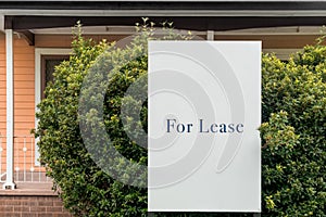 For lease sign on a white display outside of a house in Australia. Investment property real estate concept