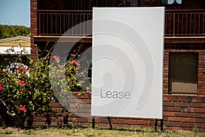 For lease sign on a white display outside of a resedential building in Australia. Investment property real estate