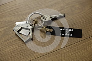 Leasehold vs freehold concept. House key on wooden table photo