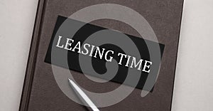 LEASING TIME sign written on the black sticker on the brown notepad. Tax concept