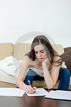 Leasure and home concept - calm teenage girl woman writes with p