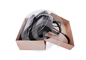 Leather backpack in a cardboard box.