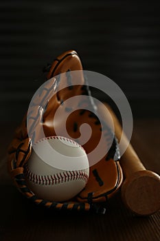 Leather baseball ball, bat and glove on table