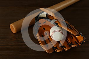 Leather baseball ball, bat and glove on table