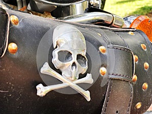 Leather biker bag with skull and bones on a motorcycle close-up. Concept travel on a motorcycle