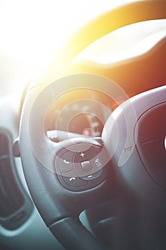 Leather-black steering wheel with remote control, modern car, blurry dashboard