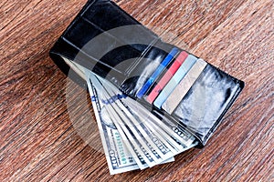Leather black wallet with dollars and credit cards