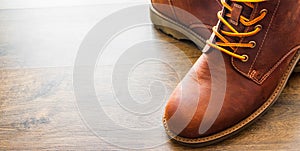 Leather boots shoes on the brown wooden table background.with copy space.